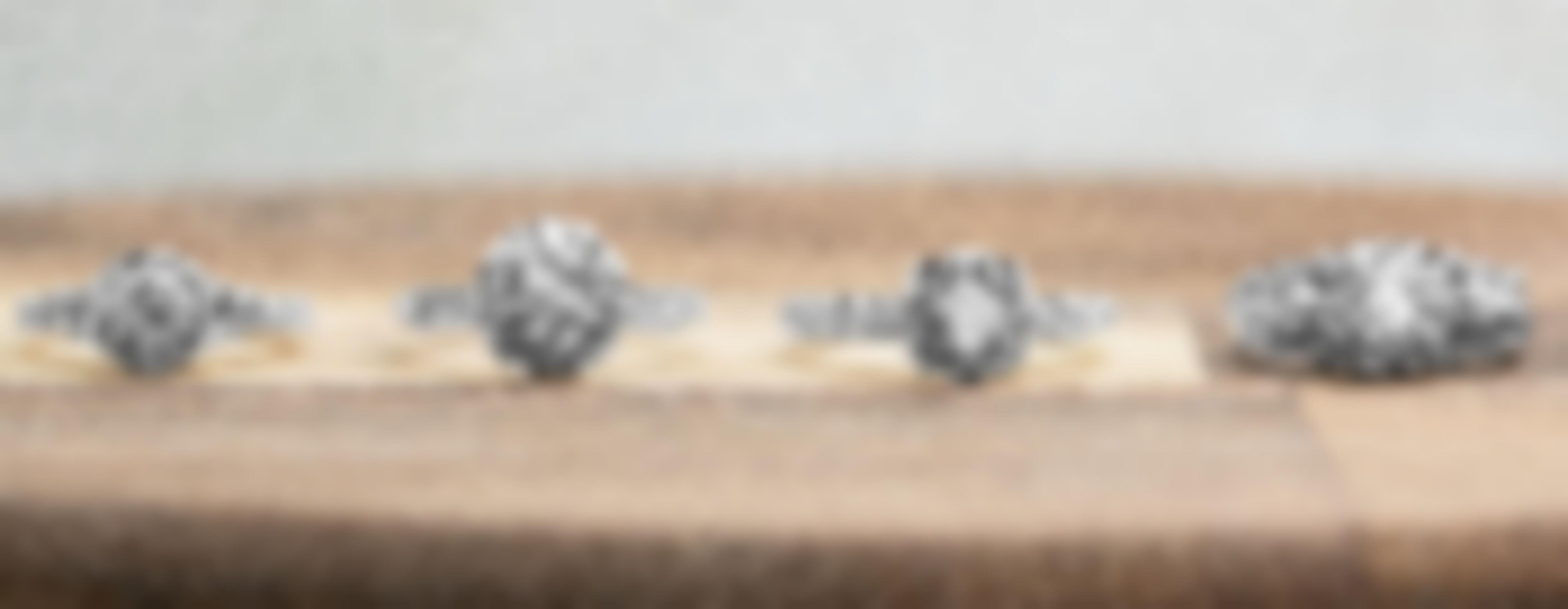 Four diamond engagement rings with diamond haloes on a wooden table.