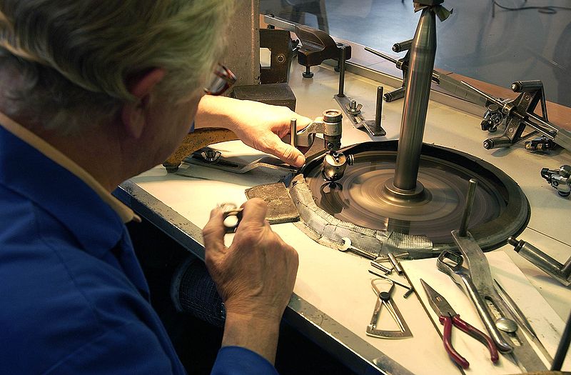 Jeweler working at bench on cutting diamonds.