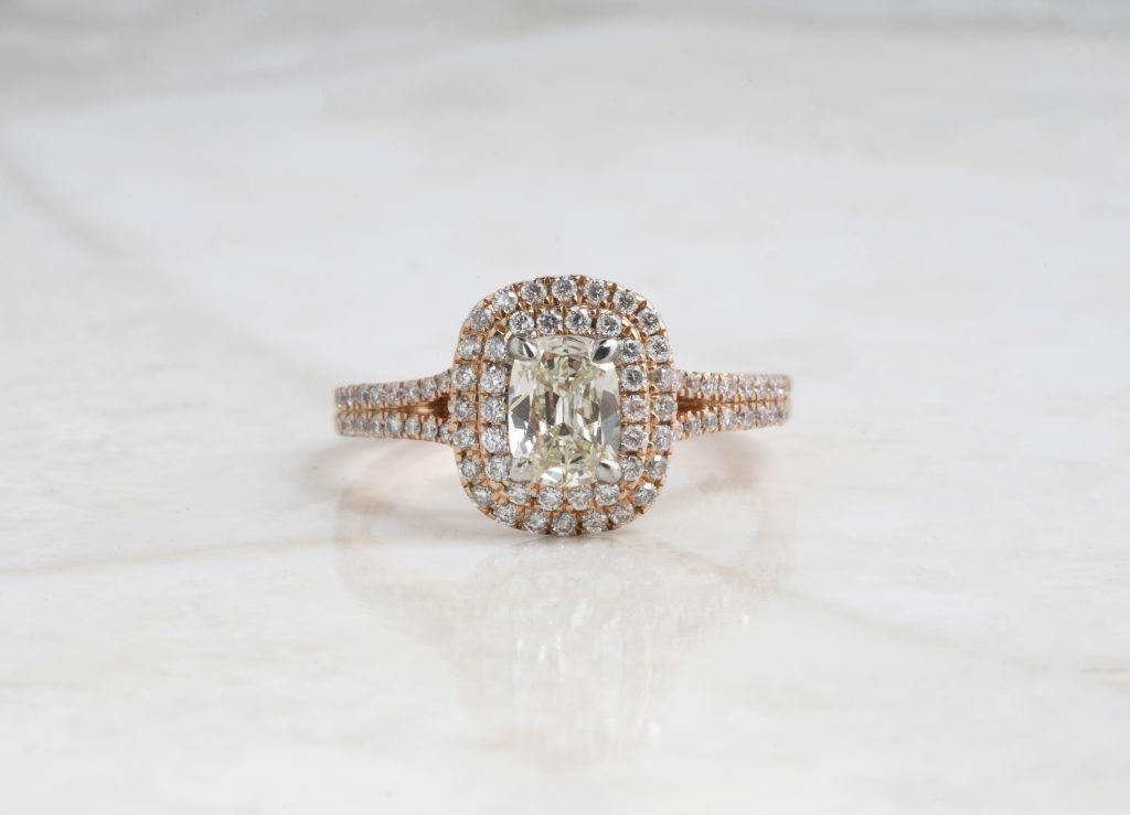 Yellow gold engagement ring centered with a diamond surrounded by a diamond double halo and diamonds in the band.