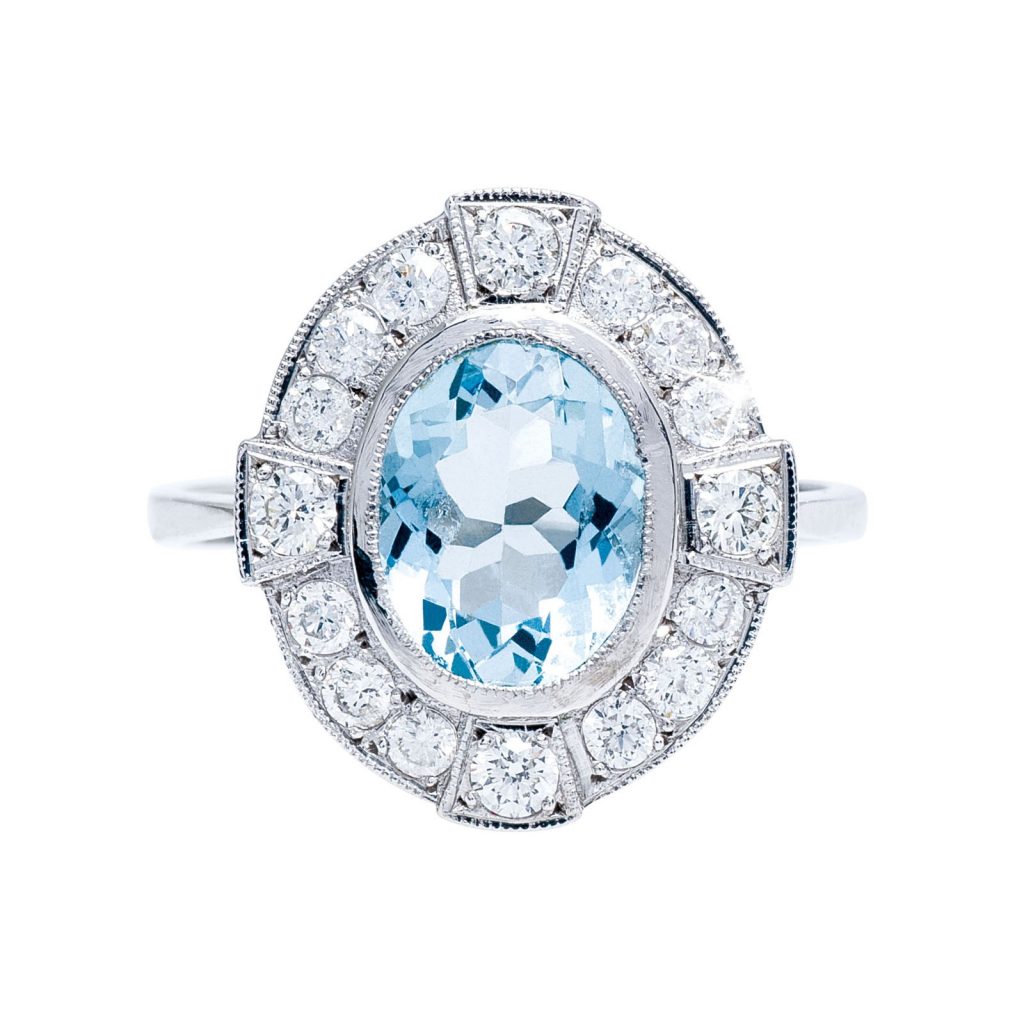 White gold engagement ring centered with an aquamarine surrounded by a diamond halo.