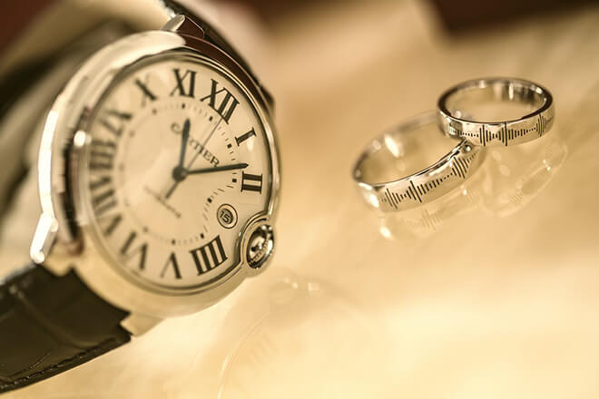 Vintage Cartier watch on table next two vintage Cartier rings.