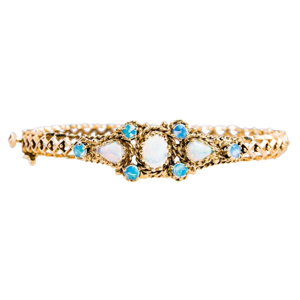 Yellow gold three-stone bracelet set with opals and blue gemstones.