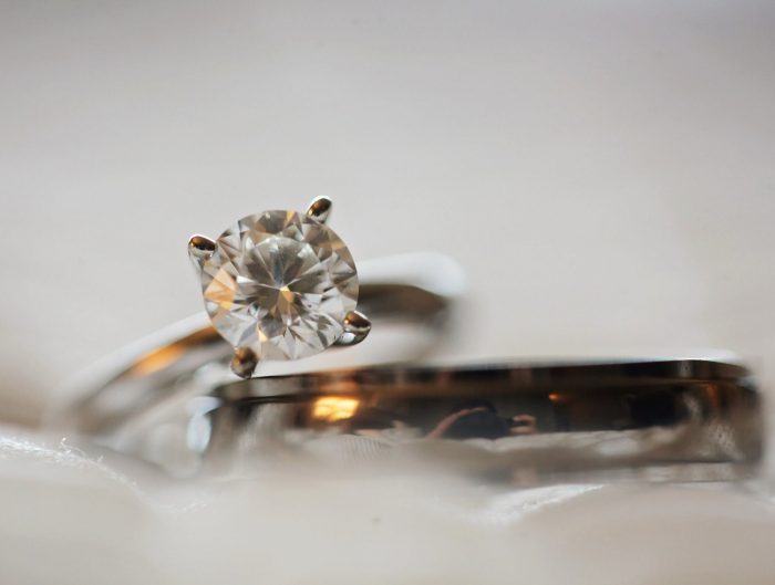 White gold diamond engagement ring stacked with a men’s wedding band.