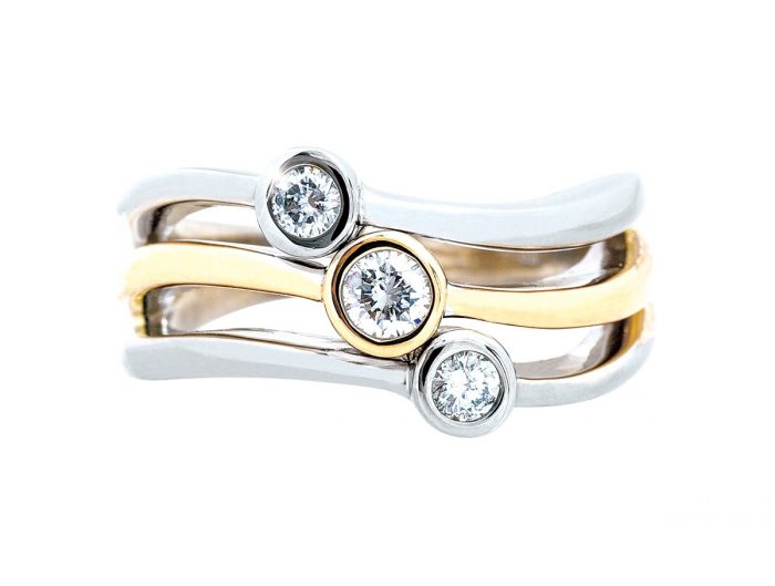 Yellow and white gold curved three-row three-stone diamond engagement ring.