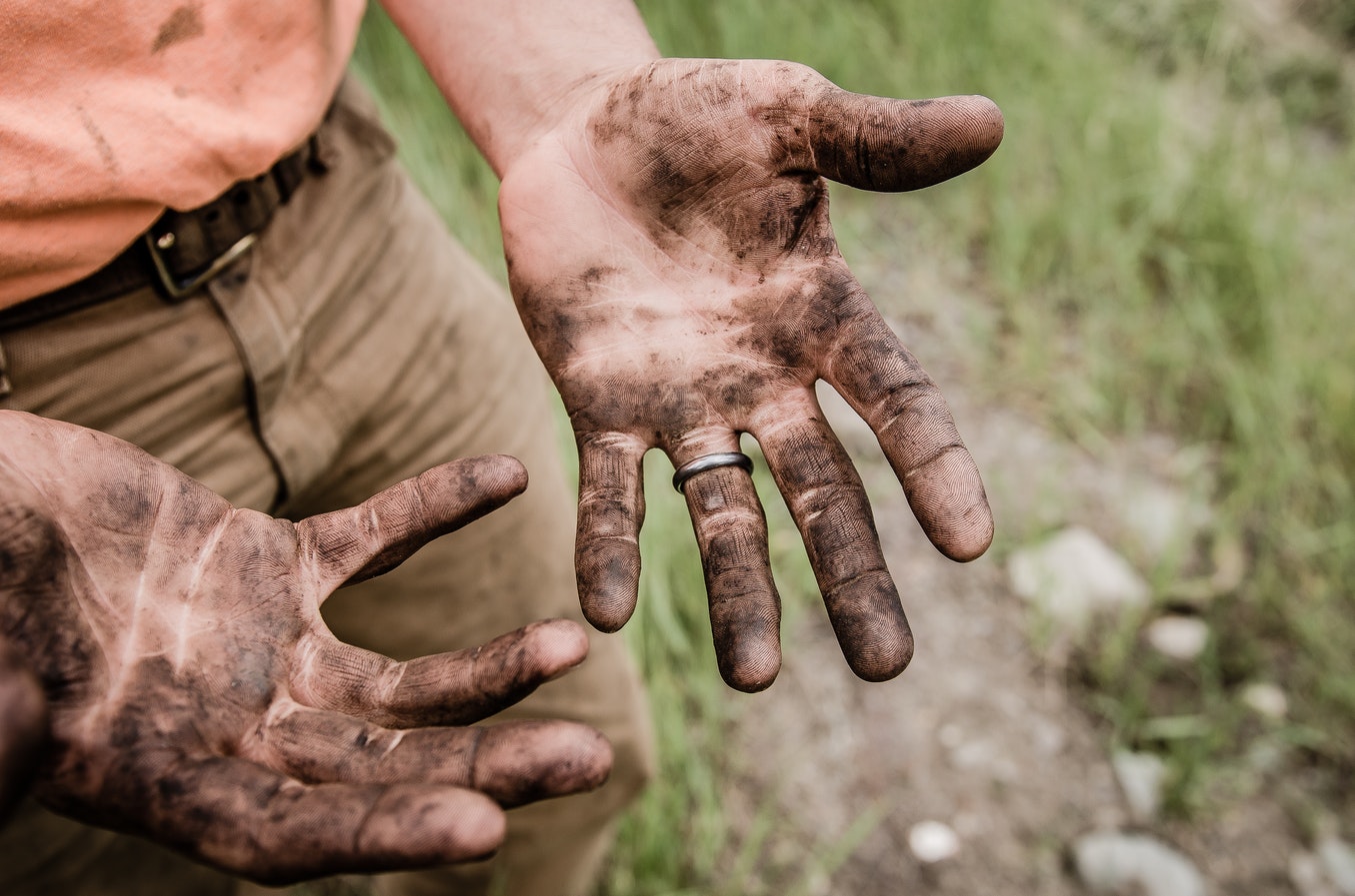 Man’s hands covered in dirt from gardening.