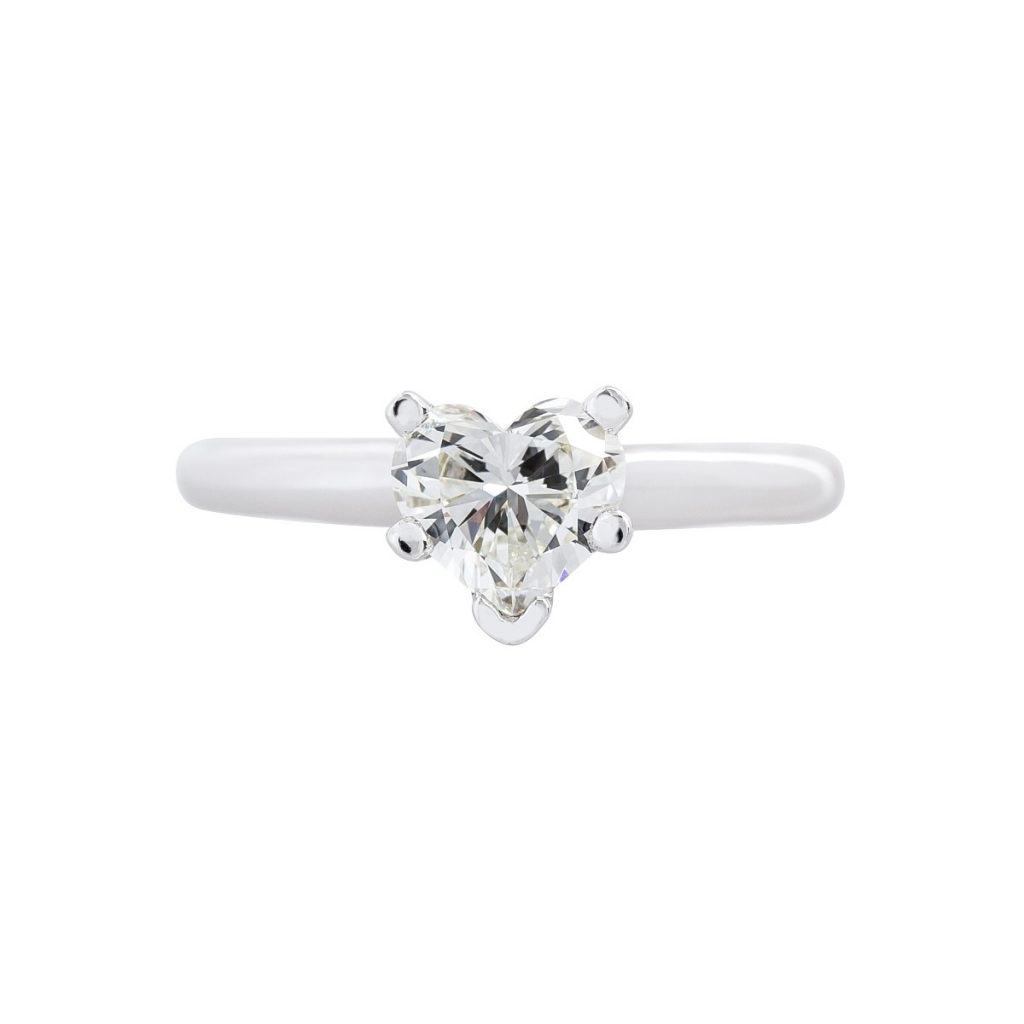 White gold solitaire engagement ring centered with a heart cut diamond.