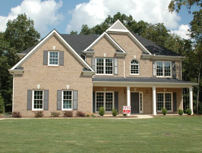 Two-story house with a porch and large front yard.