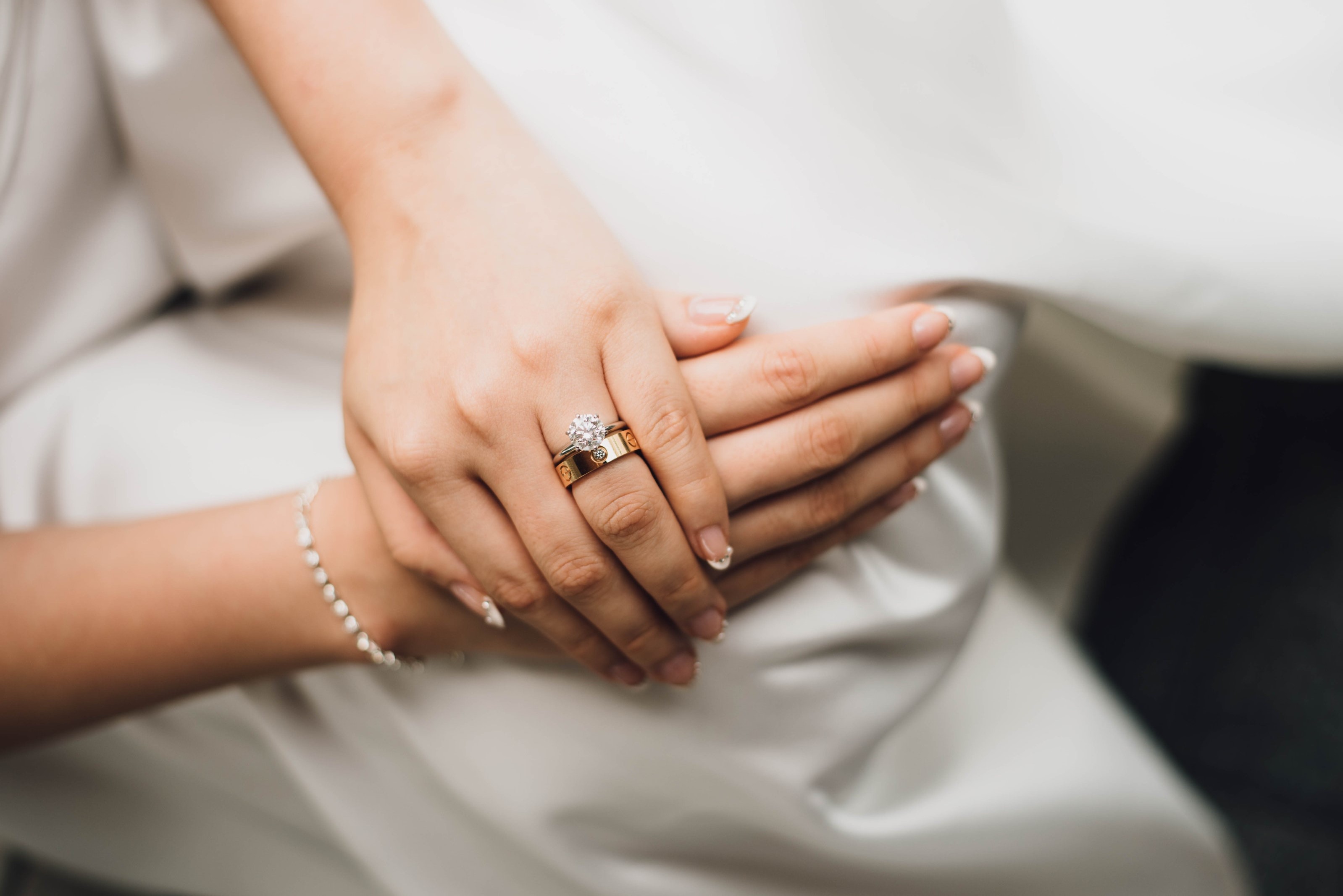 Woman’s hands featuring bracelet and wedding ring.