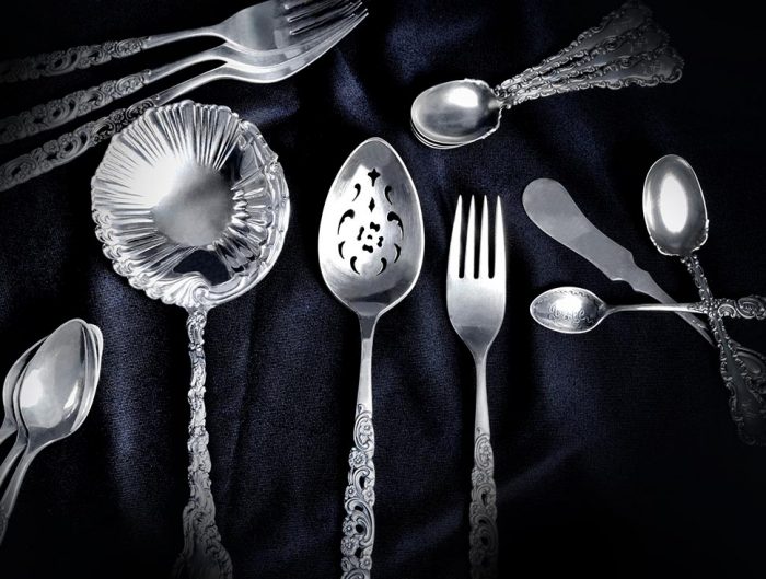 Silver flatware on a black velvet cloth.