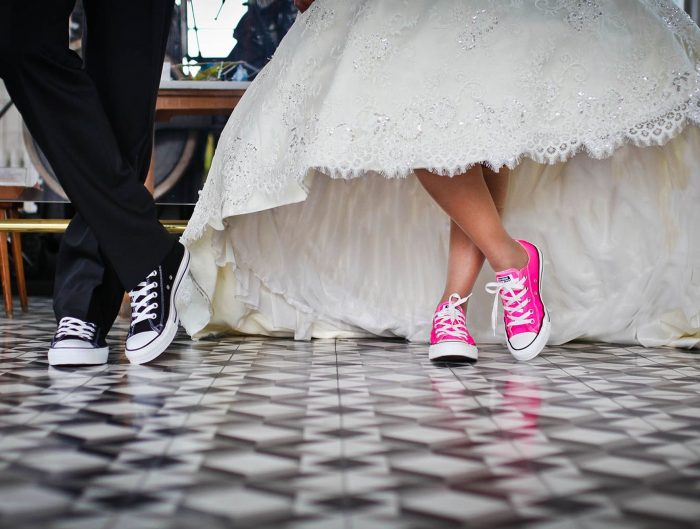 Bride and groom wearing pink and black converse for their ceremony.