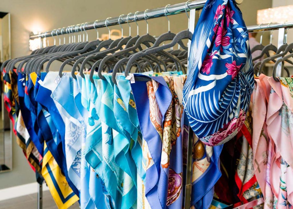 Clothing rack full of vintage designer scarves.