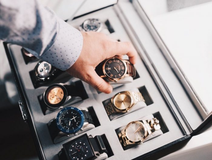 Man storing away a watch into a luxury watch box.