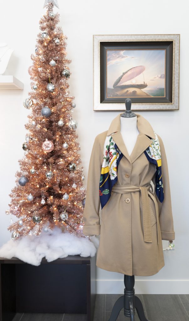 Vintage designer scarf with long coat on display in front of a Christmas tree.