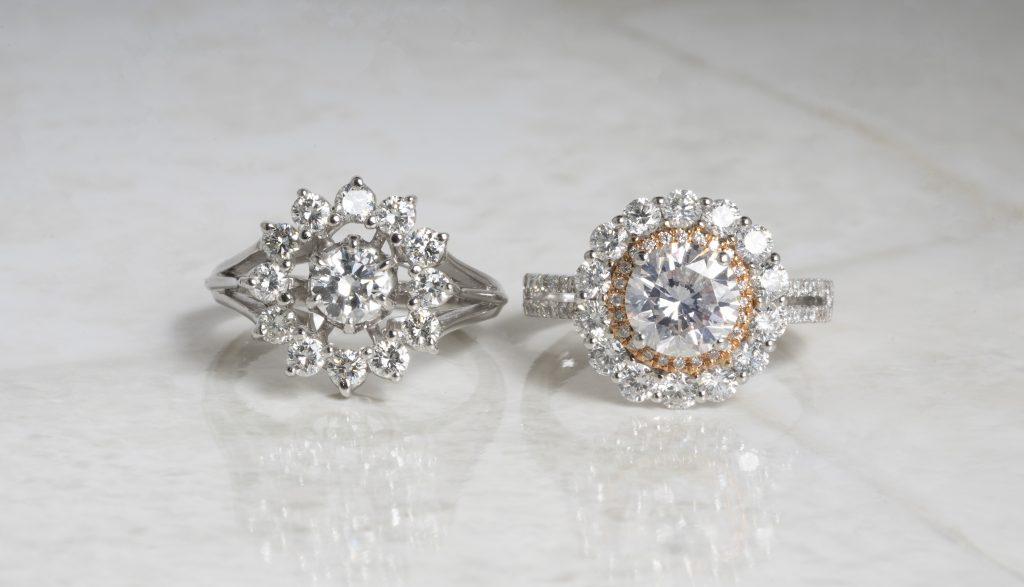 Two white gold diamond engagement rings with diamond haloes.