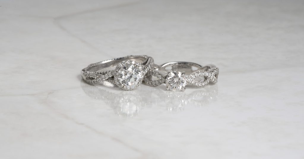 Two white gold diamond engagement rings with twisted bands.