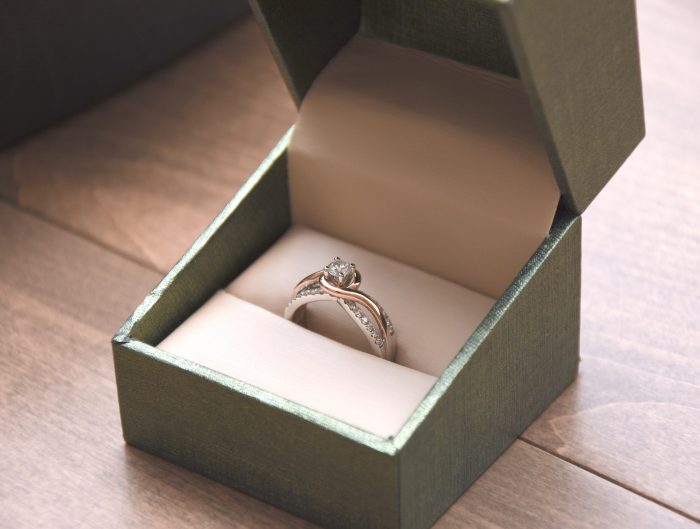 Yellow and white gold diamond engagement ring in a green ring box.