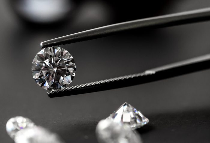 Tweezers holding a loose round cut diamond.