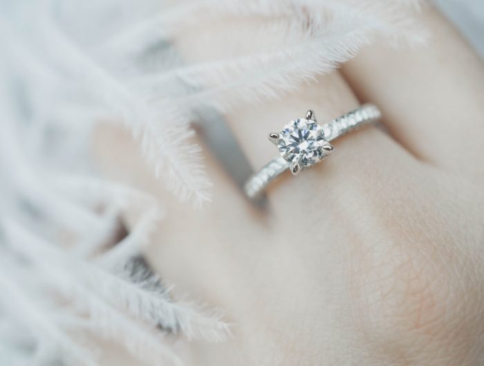 Woman’s hand featuring diamond engagement ring.