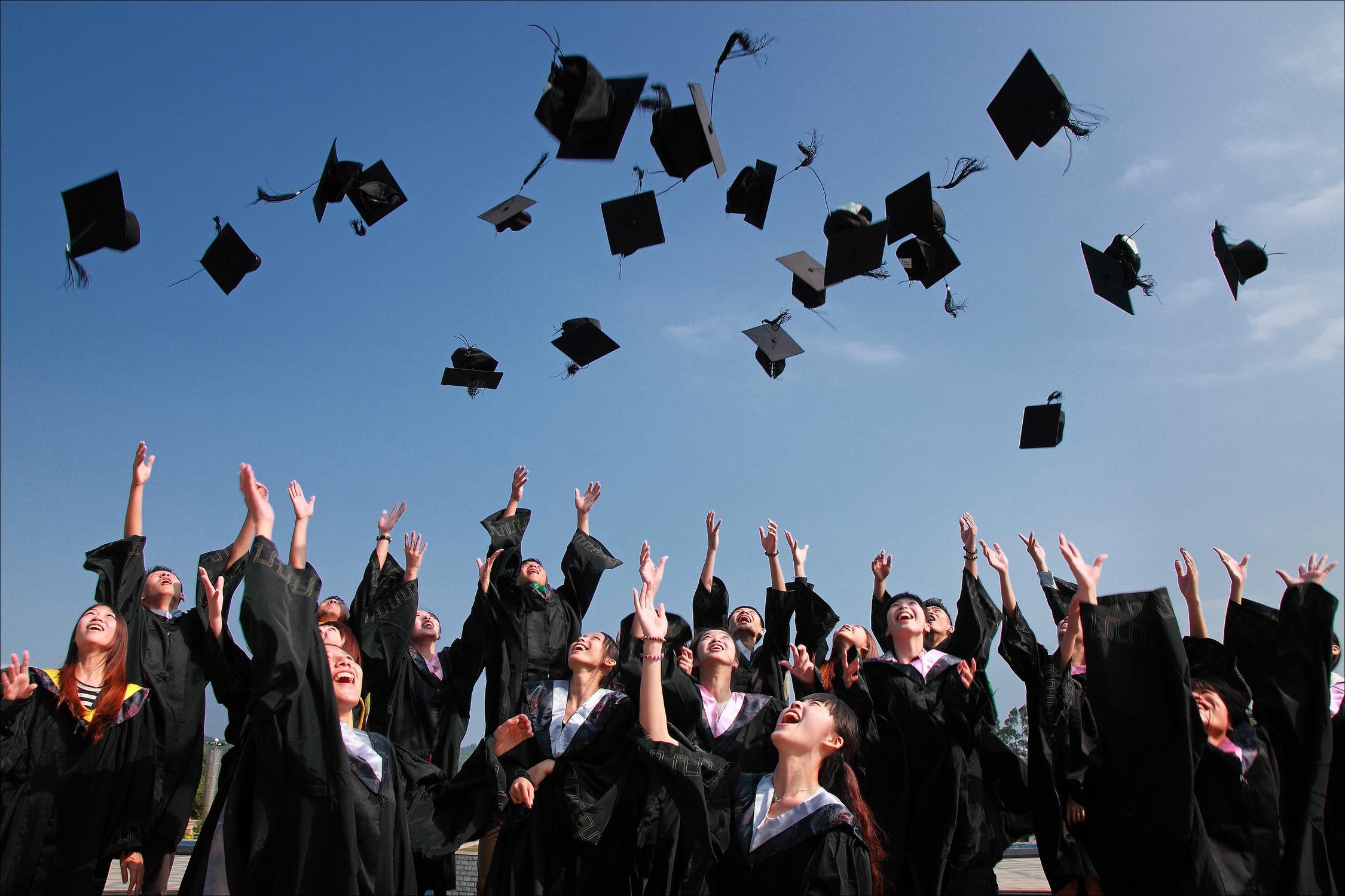 Graduates throwing caps in the air at ceremony.