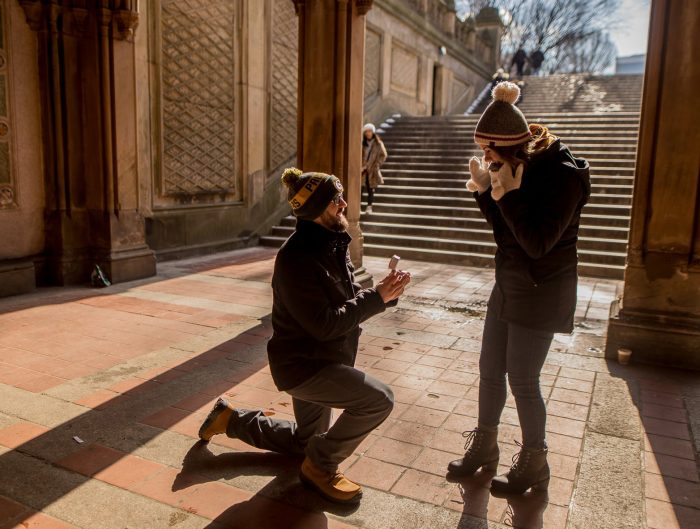 Man proposing to woman outside of historic building.