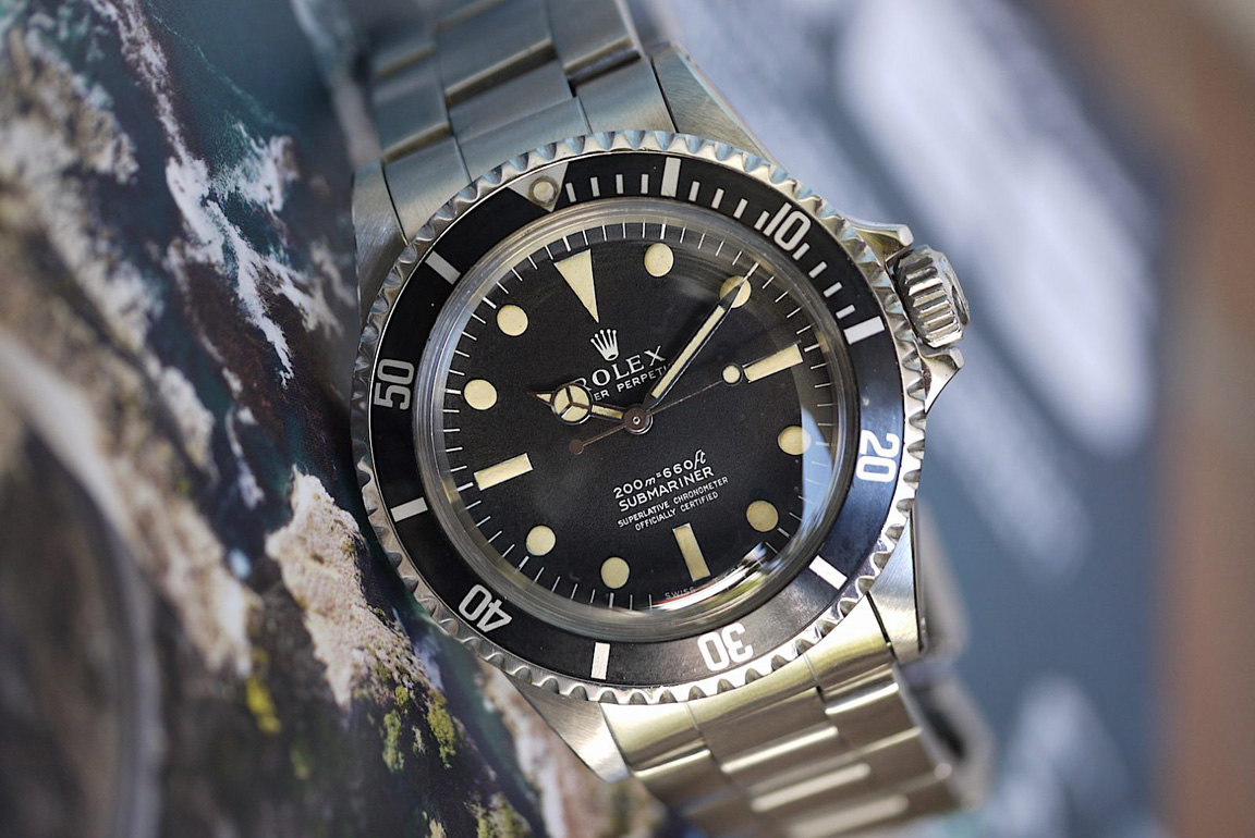 Pre-owned men's Rolex Submariner in yellow gold with a black dial.