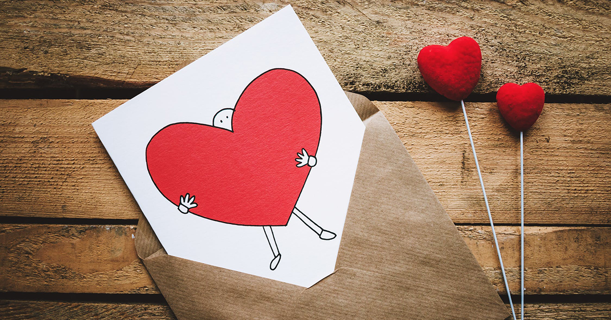 Valentine's Day card and candy on a wooden table.