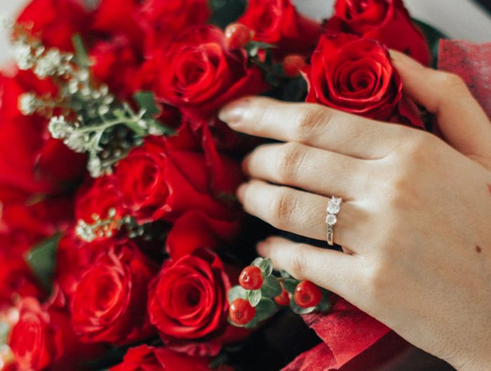 Woman holding a bouquet of red roses.