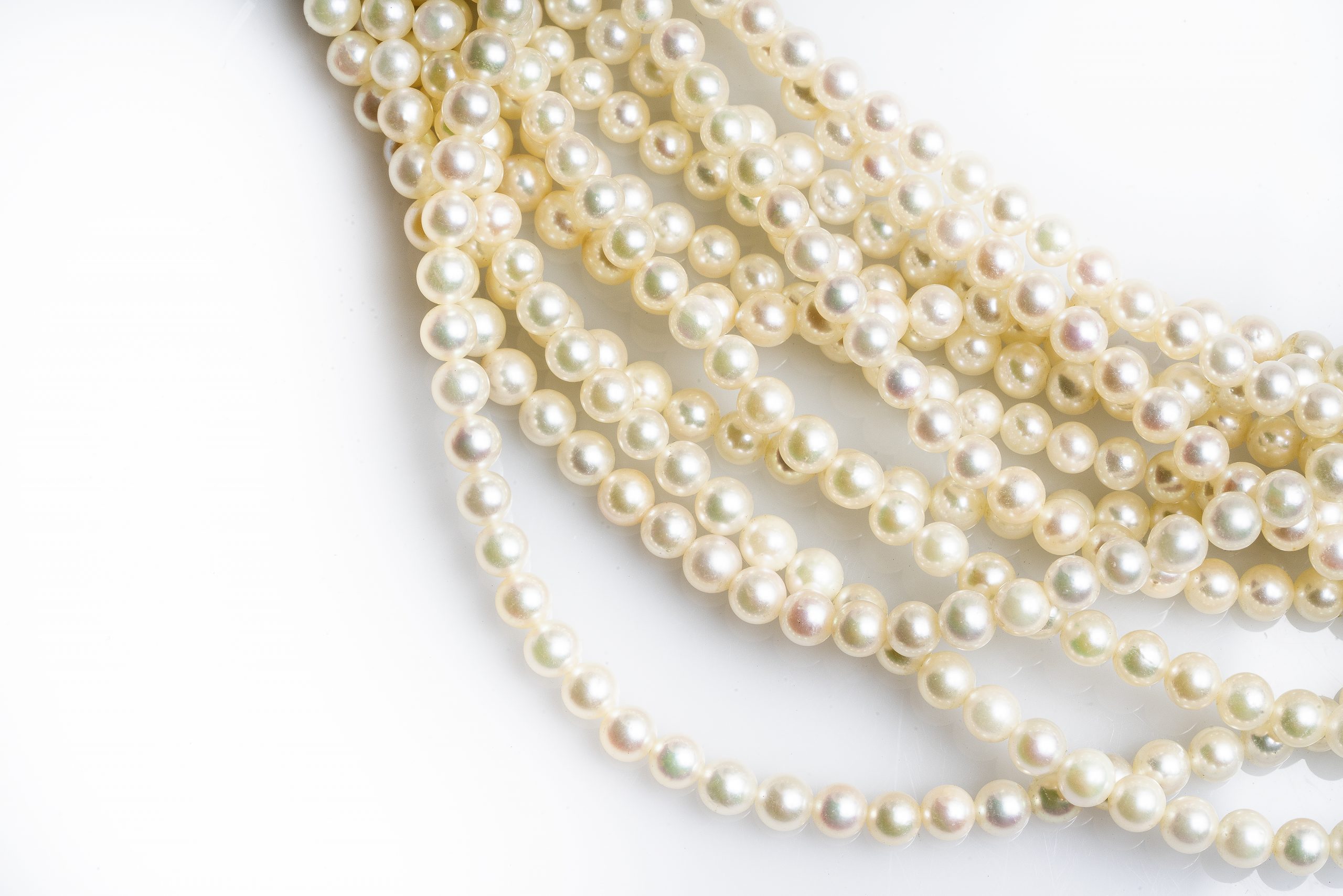 Pile of white pearl strand necklaces.