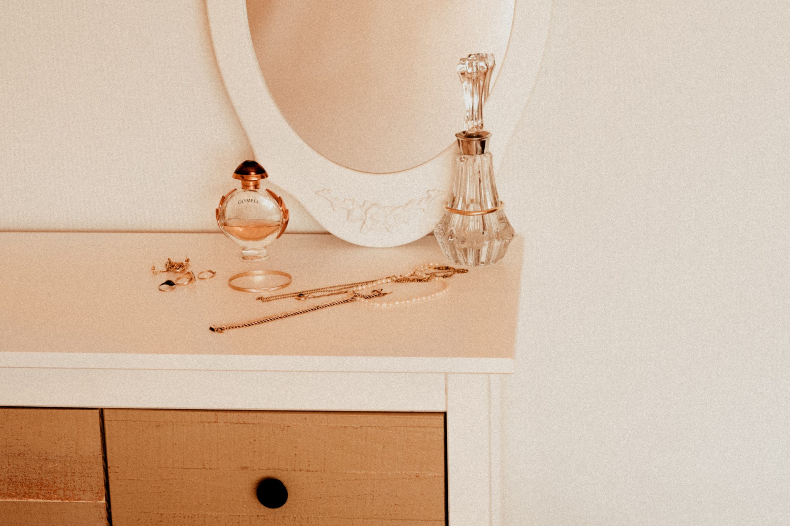 Assorted jewelry pieces laid out on top of vanity cabinet.