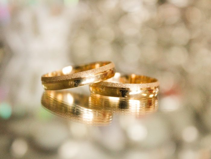 Two stacked yellow gold wedding bands.