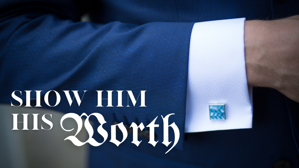 Men’s arm in blue suit featuring light blue cufflinks with text “Show Him His Worth”.