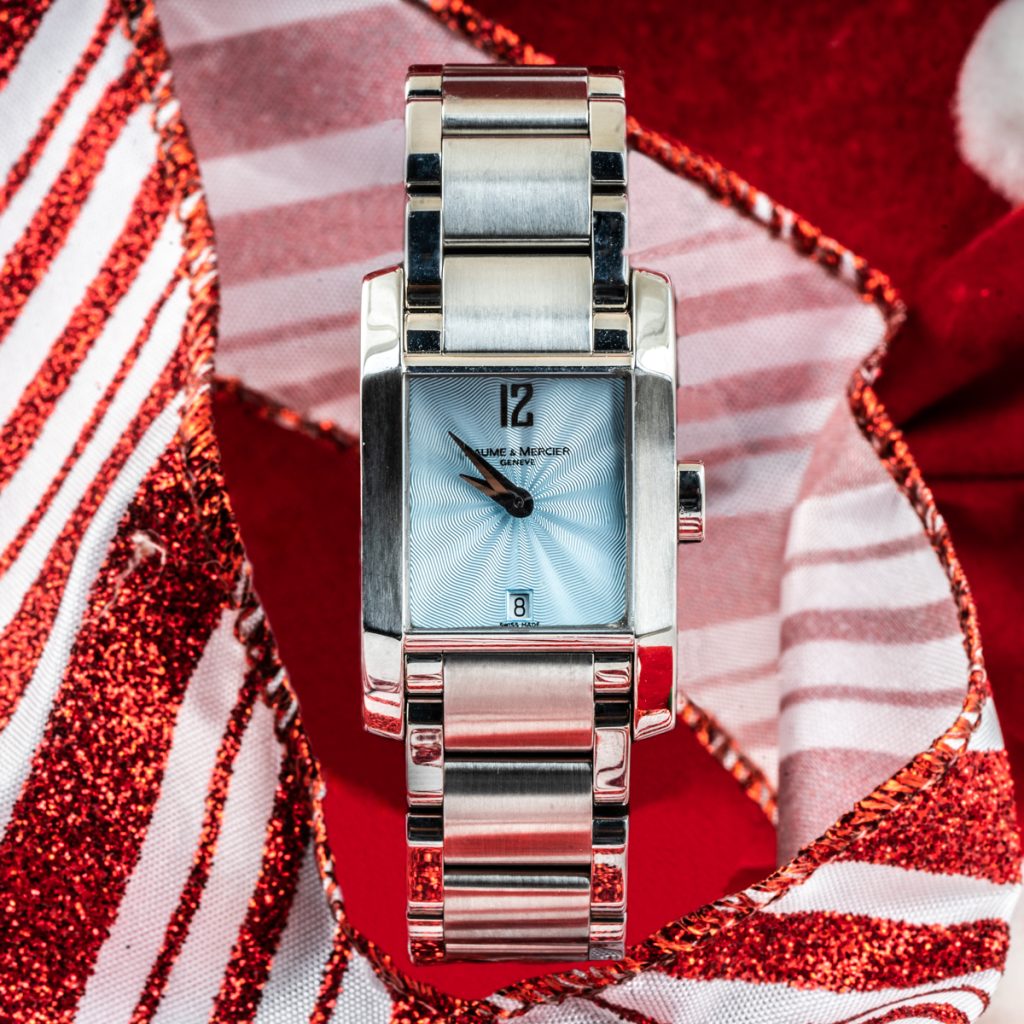 Pre-owned women’s Baume & Mercier Diamant 34mm on a red and white striped ribbon background.