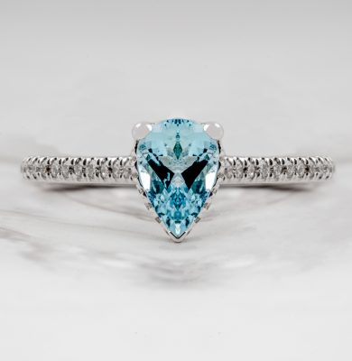 White gold engagement ring centered with an aquamarine and diamonds in the band.