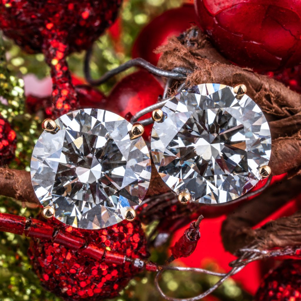 New lab-grown diamond stud earrings displayed on mistletoe.