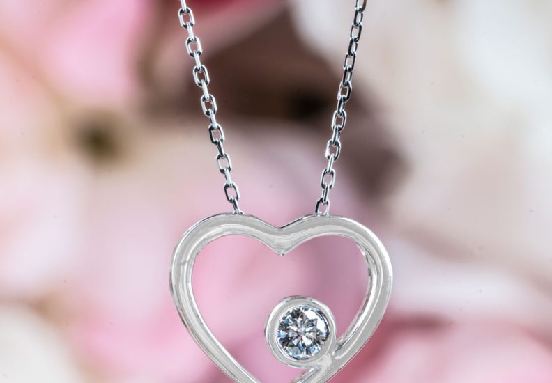 White gold heart necklace set with a single round brilliant cut diamond.