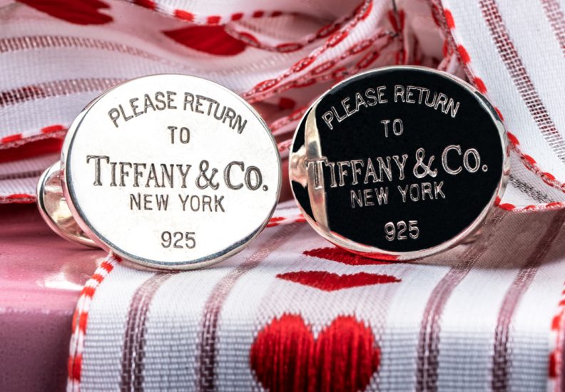 Vintage Tiffany & Co. Please Return to Tiffany cufflinks on a heart ribbon background.