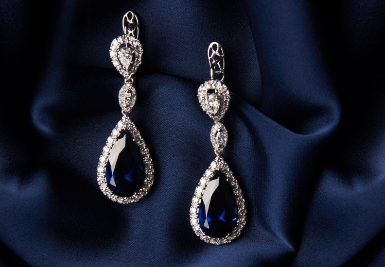 White gold drop earrings set with pear cut blue sapphires and diamond haloes.