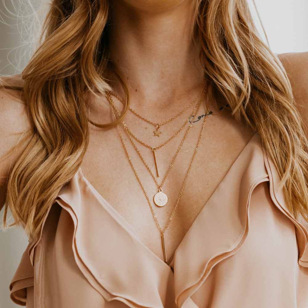 woman wearing four layered necklaces