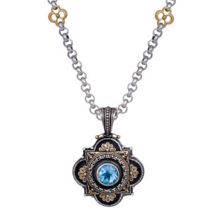 Fancy gold and silver pendant with a bright blue round topaz in the center