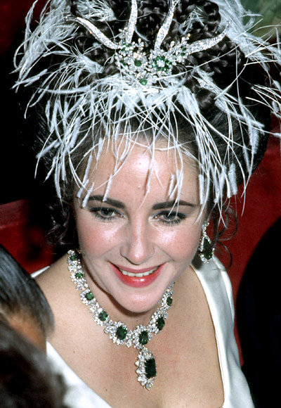 Elizabeth Taylor pictured wearing one of her emerald and diamond statement necklaces, this link will open in a new window.