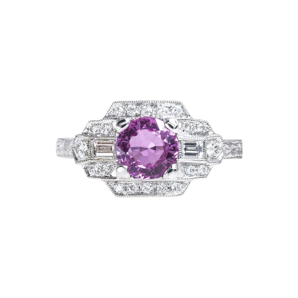 White gold engagement ring centered with a purple gemstone surrounded by a diamond
halo.