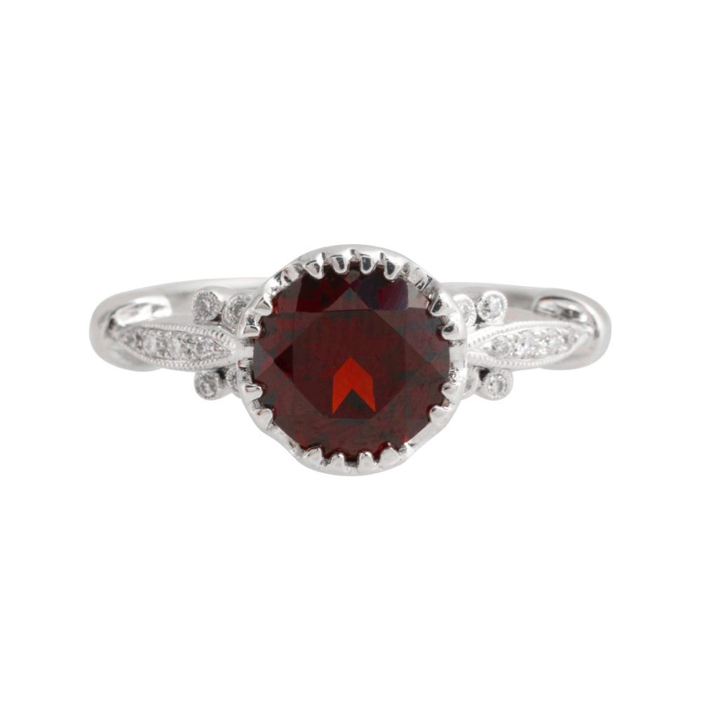 White gold ruby ring with diamond halo and diamonds in the band.