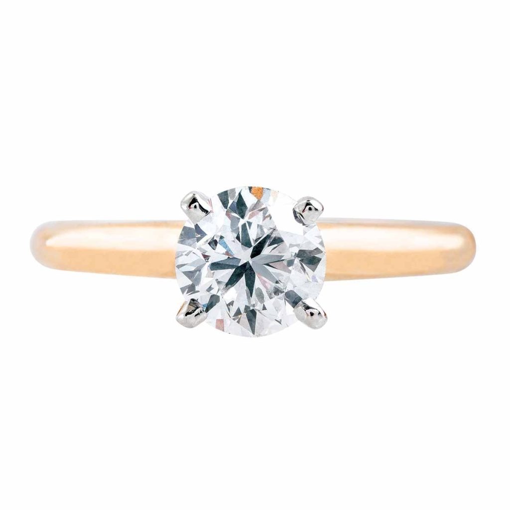 Classic solitaire engagement ring with a round brilliant-cut diamond in a four-prong setting on a sleek yellow gold band.