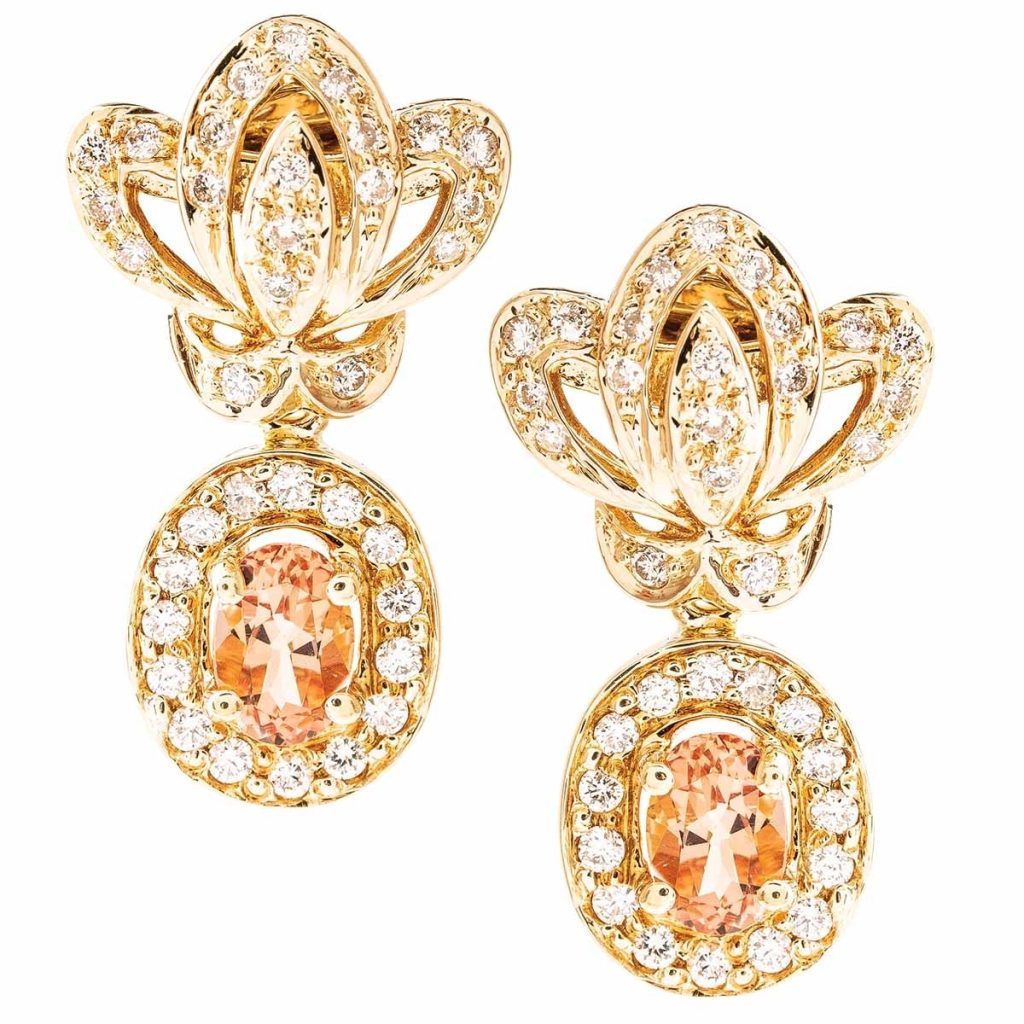 Yellow gold drop earrings set with diamonds and peach-orange gemstones.