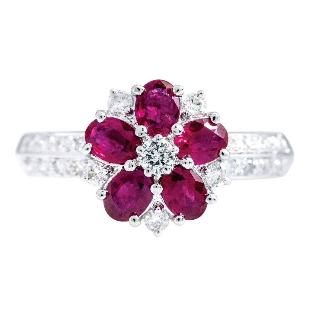 White gold flower ring set with rubies with diamonds in the band.