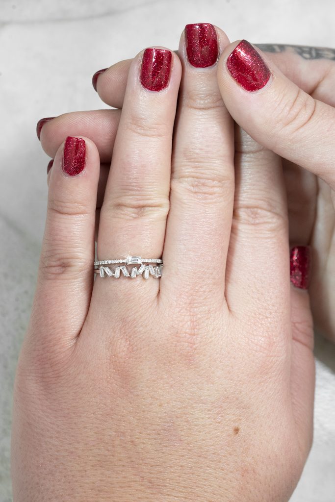 Woman wearing two white gold diamond eternity bands.