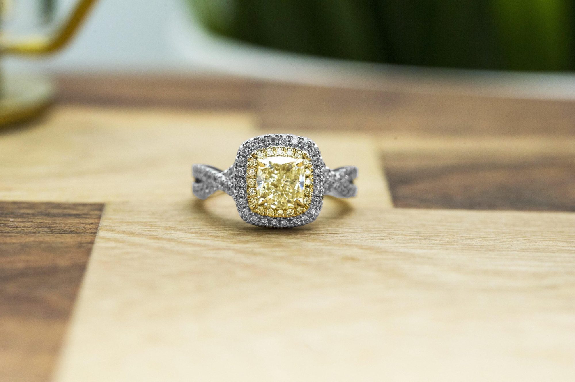 Antique platinum twist engagement ring centered with a fancy light yellow diamond and
a white diamond halo.