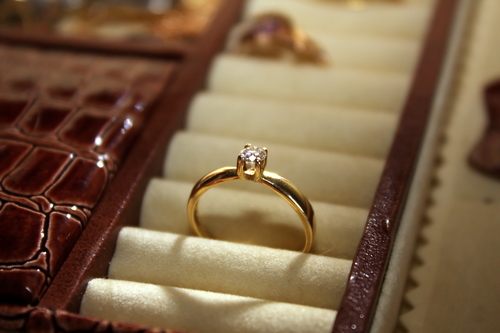 Yellow gold solitaire engagement ring in storage box.