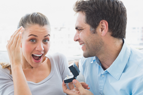 Woman surprised by man proposing.