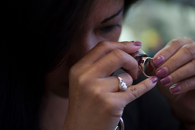 Jeweler inspecting ring through her loupe.